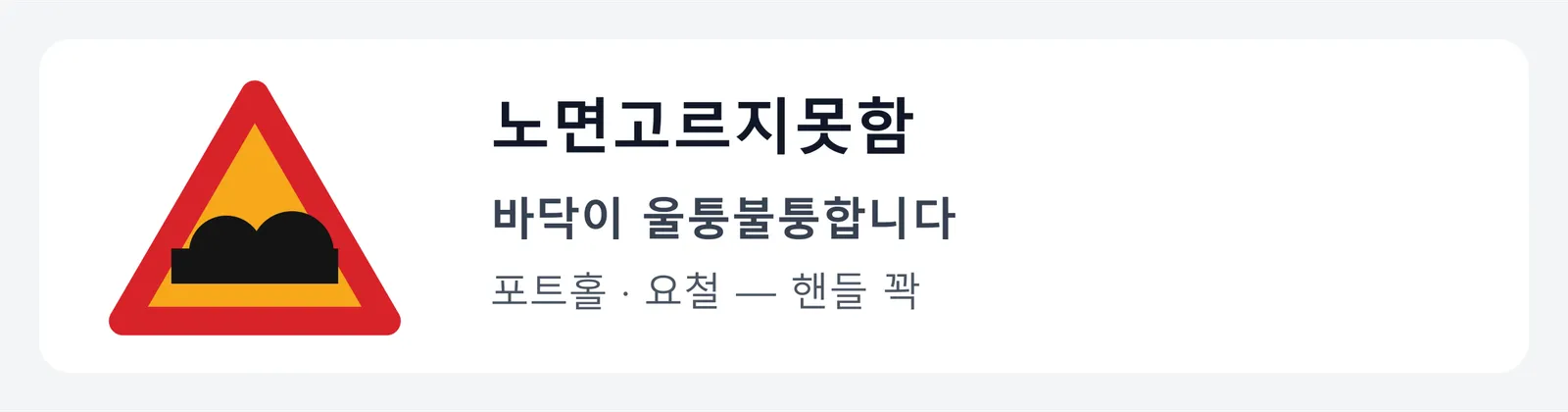 노면고르지못함 표지판. 바닥에 둥근 혹 두 개가 솟은 그림으로, 포트홀이나 요철로 바닥이 울퉁불퉁하니 핸들을 꽉 잡으라는 뜻이다.